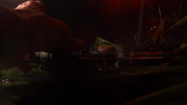 Slow  motion 4k jungle miltary scene knife and hand grenage with camera dolly movement and rain - hand come in in the shot and pick ups hand grendae in the rain