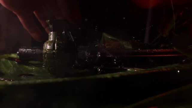 Slow  motion 4k jungle miltary scene knife and hand grenage with camera dolly movement and rain - man hand picking up knife an lifting it out of frame