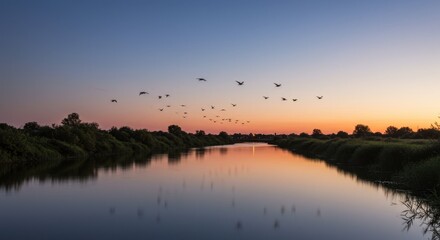 Fototapeta premium Serene Sunset Landscape: Birds in Flight Over a Calm River at Dusk