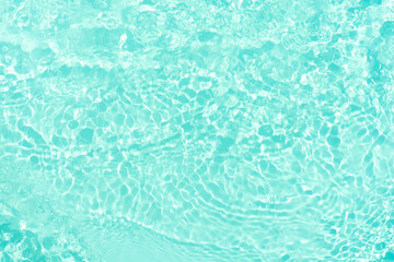 Blue water with ripples on the surface. Defocus blurred transparent blue colored clear calm water surface texture with splashes and bubbles. Water waves with shining pattern texture background.