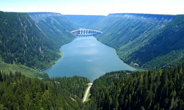 Breathtaking aerial view of a mountain dam and reservoir surrounded