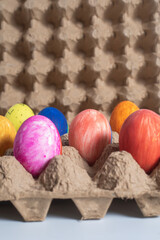 Brightly colored Easter eggs in a recycled cardboard egg carton