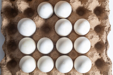 A carton of a dozen fresh white eggs arranged in a grid pattern.