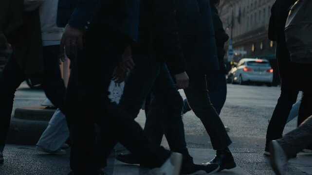 People crossing a parisian street at sunset