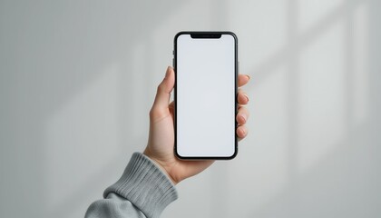 Man holding smartphone, Mobile Phone Mockup with Blank White Screen on Plain White Wall