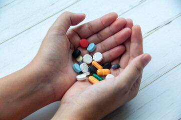 Hand holding variety of colorful pills and capsules. Medical and health matters concept.