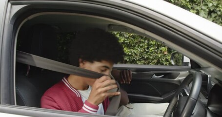 Diverse father and son talking in car, bonding during drive through neighborhood