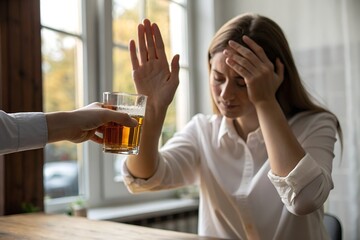 Alcoholism, depressed asian young woman hand refuse alcoholic beverage, drink whiskey while person holding glass give to her. Treatment of alcohol addiction, having suffered abuse problem alcoholism.