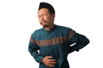 Asian Muslim man experiencing stomach pain, clutching his abdomen, isolated on a white background