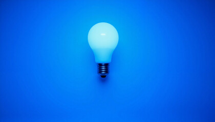 Glowing light bulb against blue background