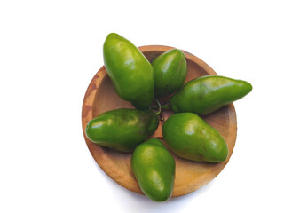 Fresh green chili fruits displayed in a wooden bowl on a white background.
