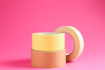 Rolls of different masking tapes on pink background