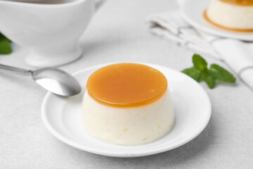 Tasty pudding with caramel sauce served on white table, closeup