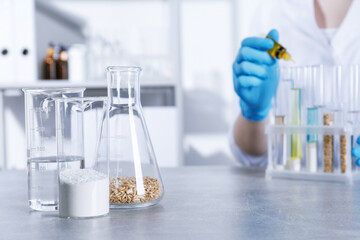 Laboratory testing. Scientist dripping liquid into test tube at table indoors, focus on glassware with sample