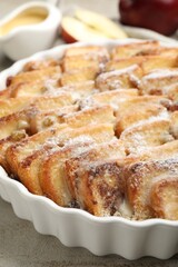 Delicious bread pudding with raisins and powdered sugar on grey table, closeup