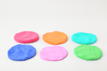 Different colorful play dough on white background, closeup