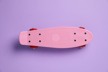 One penny board on violet background, top view. Sports equipment