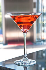 Cosmopolitan, Red Cosmopolitan cocktail in a martini glass isolated on a bar counter, drink
