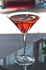 Cosmopolitan, Red Cosmopolitan cocktail in a martini glass isolated on a bar counter, drink