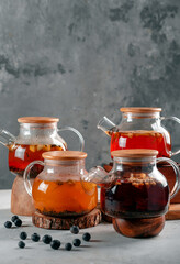 Various types of tea in teapots on a stone table. Tea fruit hot drinks for health