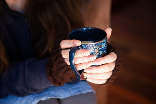 Person holding cup of chai tea in winter to keep warm