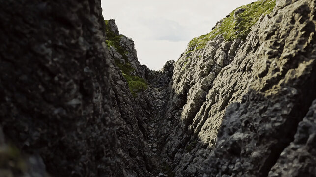 Dramatic rocky cliff rising steeply against a clear blue sky showcasing the raw beauty of nature in an ancient canyon landscape.