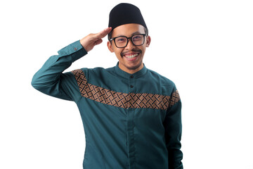 Happy Indonesian Muslim man performs a salute gesture while smiling and looking directly at the camera, Isolated on a white background. Respect, greeting, or a welcoming gesture concept