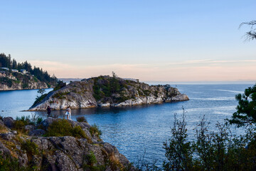 &ldquo;A stunning rocky islet at Horseshoe Bay, Vancouver, surrounded by clear waters. A couple with their dog watches as adventurers dive in, blending serene beauty with thrilling energy.&rdquo;