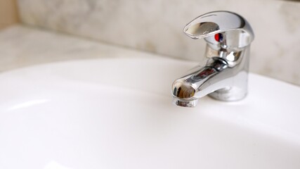 A chrome faucet into sink in bathroom