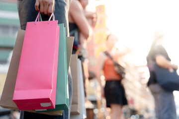 Obraz premium Beautiful young woman holding shopping bags during sale. She is dressed stylishly and enjoys shopping to the fullest. There is fun and excitement of shopping therapy.
