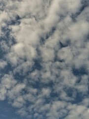 Soft white clouds drifting across a blue sky.