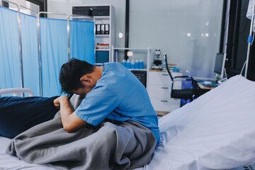 Lonely man silhouette sitting on the bed feeling depressed and stressed in the dark bedroom, Depression and anxiety disorder concept