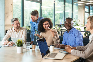Group of young modern people using modern technologies while working in the creative office