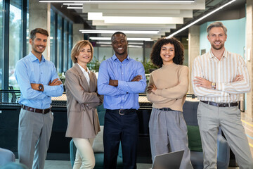 Portrait of successful creative business team looking at camera and smiling. Diverse business people standing together at startup.