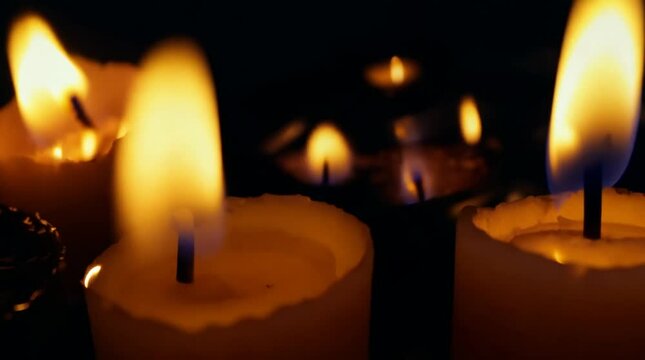 Many small burning candles on a black background