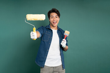 "Portrait of an Asian male painter posing against a green background."