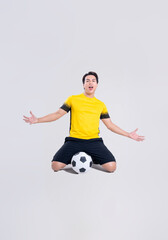 Fototapeta premium Portrait of Asian man playing soccer on white background