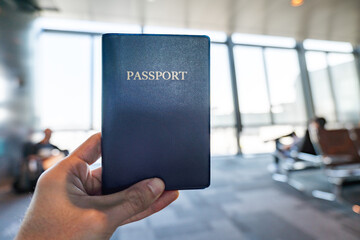 Passport held in hand, at airport, close-up