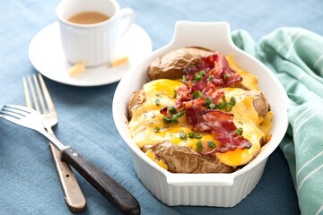 Baked potatoes with cheese sauce, eggs and bacon for breakfast