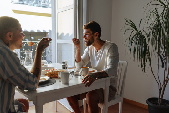 Gay couple enjoying breakfast together at home