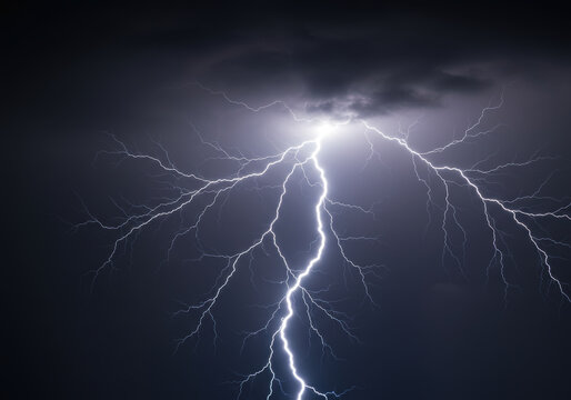A bright lightning bolt flashes in the dark sky during a powerful thunderstorm.