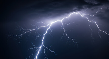 A powerful display of lightning illuminates the night sky during a thunderstorm.