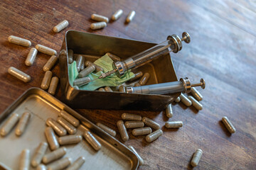 Several syringes and capsules on a wooden surface.