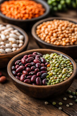healthy plant-based protein, small bowls filled with various beans (black beans, white beans, red kidney beans, lentils) on a wooden table, close-up shot,