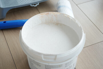 White paint ready for application on a wooden floor