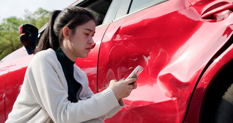 Disappointed woman watching her car get damaged due to an accident. A female driver was involved in a car accident and needed help with insurance and roadside assistance. It was an emergency situation