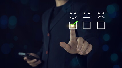 Customer service and Satisfaction concept ,Business people are touching the virtual screen on the happy Smiley face icon to give satisfaction in service. rating very impressed.