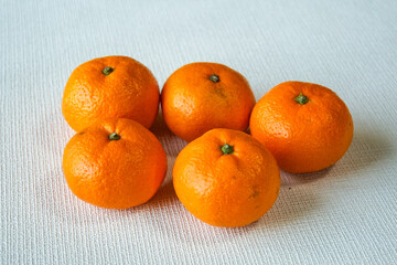 白い背景に置かれた食卓を彩るみずみずしい５つの新鮮なみかん