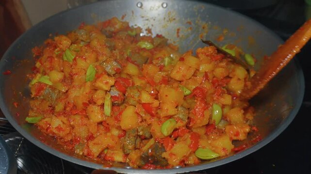 Cooking Indonesian traditional food named "Sambal Goreng Ati Ampela Pete" i.e. Hot spicy chicken gizzard and heart cooked with bitter bean