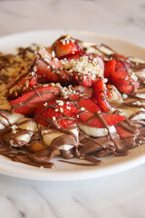 Delicious dessert with strawberries, bananas, and chocolate sauce